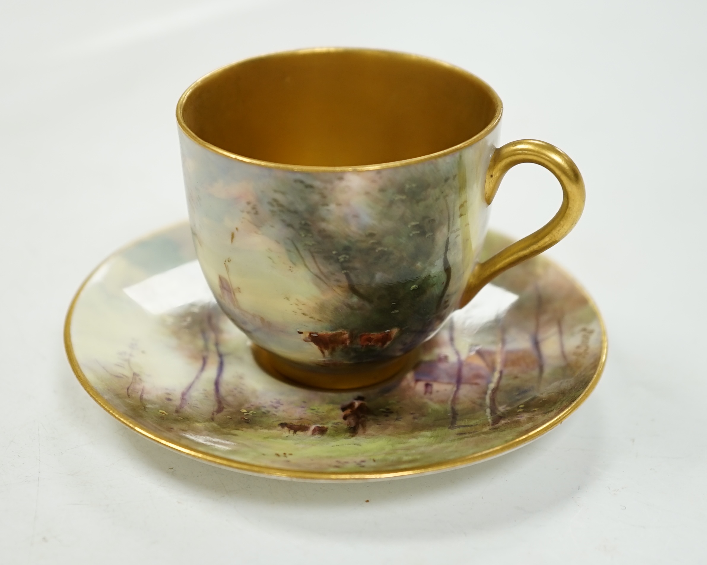 A Royal Worcester cup and saucer, painted by Harry Davis with figures in a landscape, saucer 9.5cm diameter. Condition - good